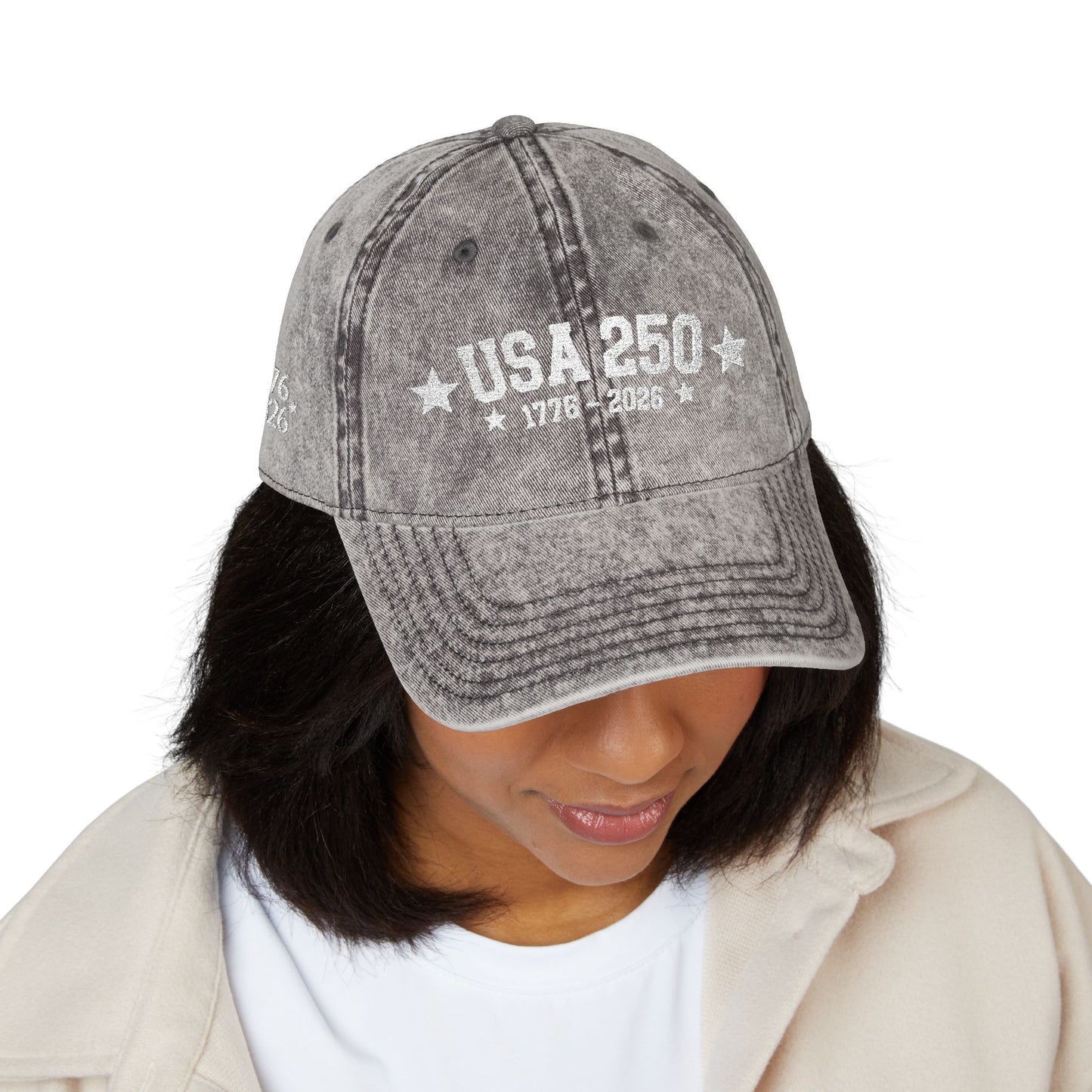 Gray denim cap with 'PRAY all day' text worn by a person on a white background