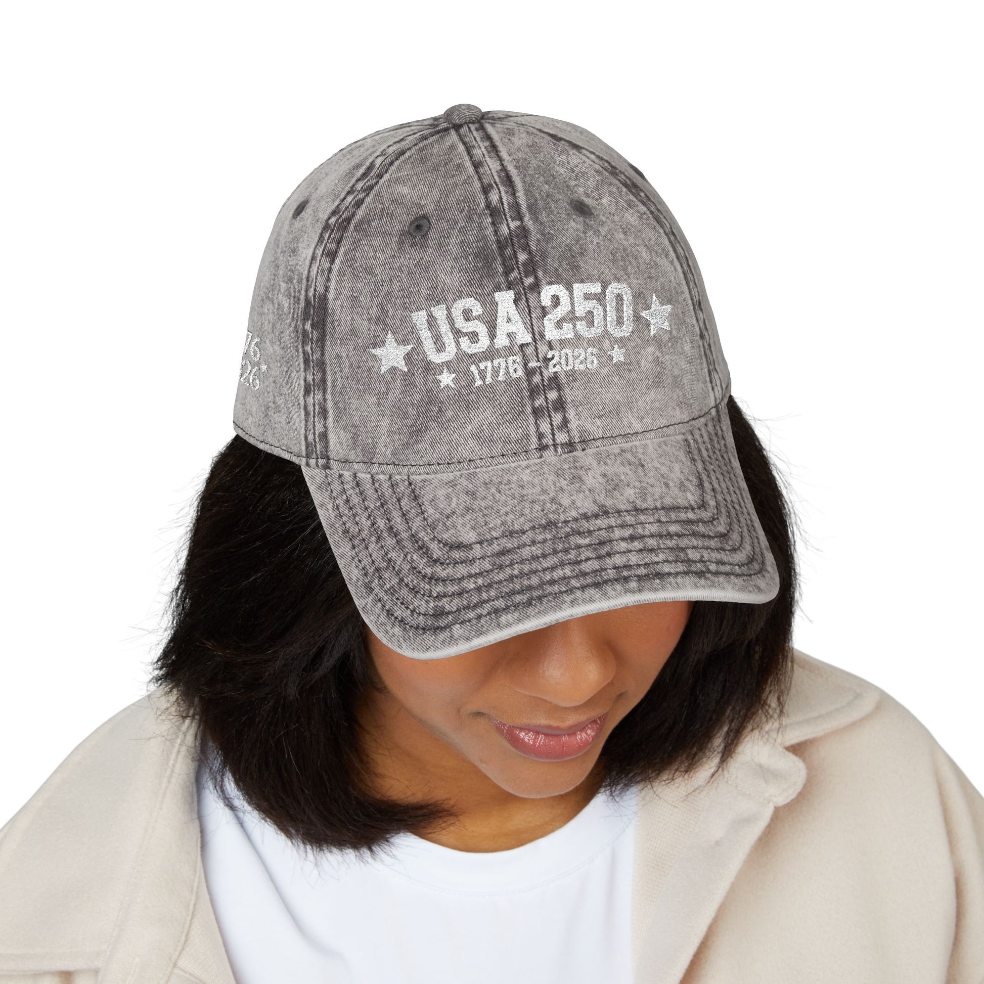 Gray denim cap with 'PRAY all day' text worn by a person on a white background
