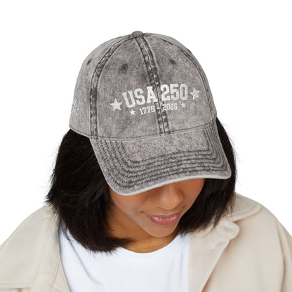 Gray denim cap with 'PRAY all day' text worn by a person on a white background