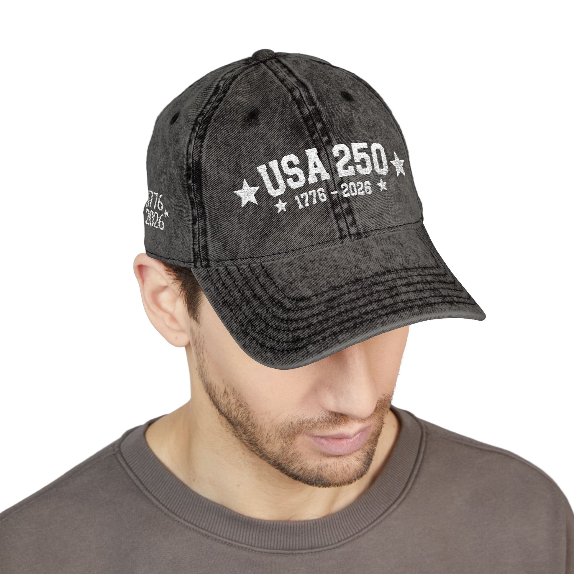 Black denim cap with 'USA 250' text worn by a person on a white background