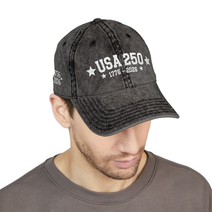 Black denim cap with 'USA 250' text worn by a person on a white background