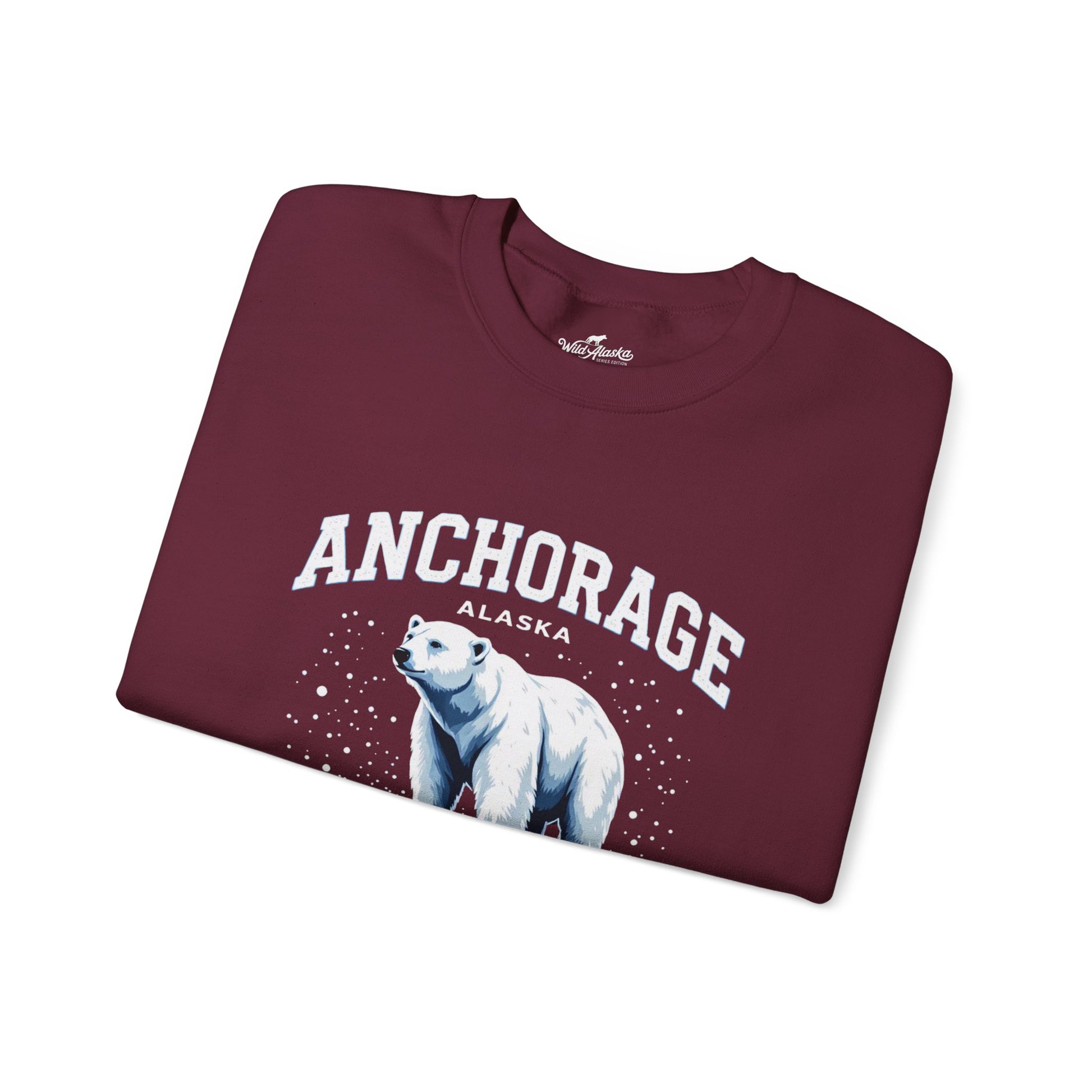 Folded maroon sweatshirt with 'Anchorage Alaska' and polar bear design on a white background