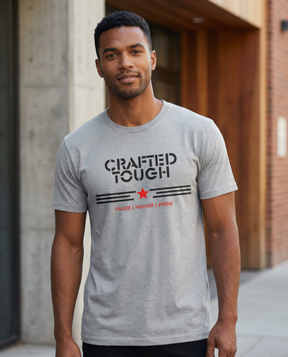 Man wearing a gray t-shirt with 'Crafted Tough' text and logo outdoors.
