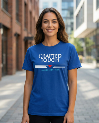 Woman wearing a blue t-shirt with 'Crafted Tough' text on a city street.