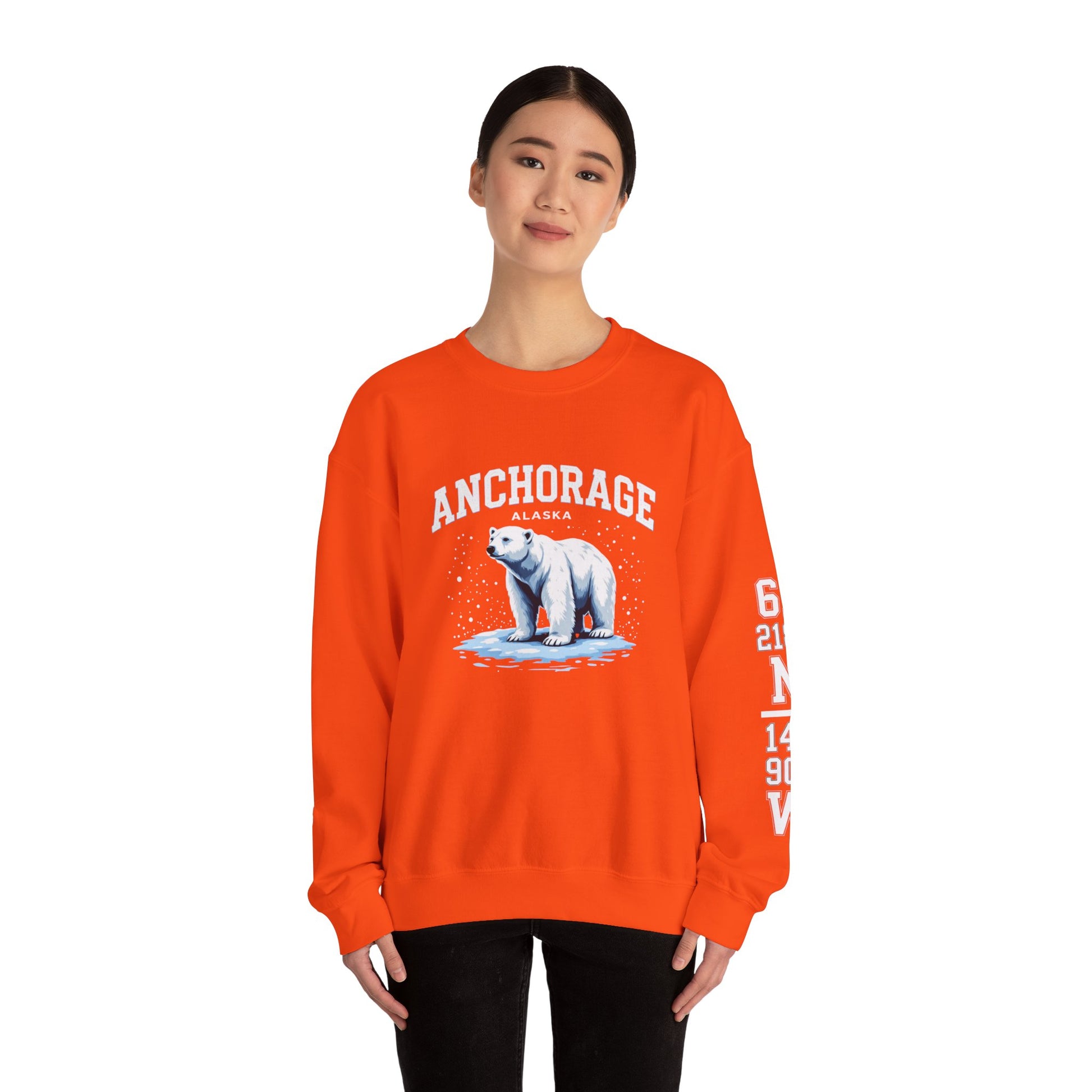 Person wearing an orange sweatshirt with a polar bear graphic and 'Anchorage' text on a white background
