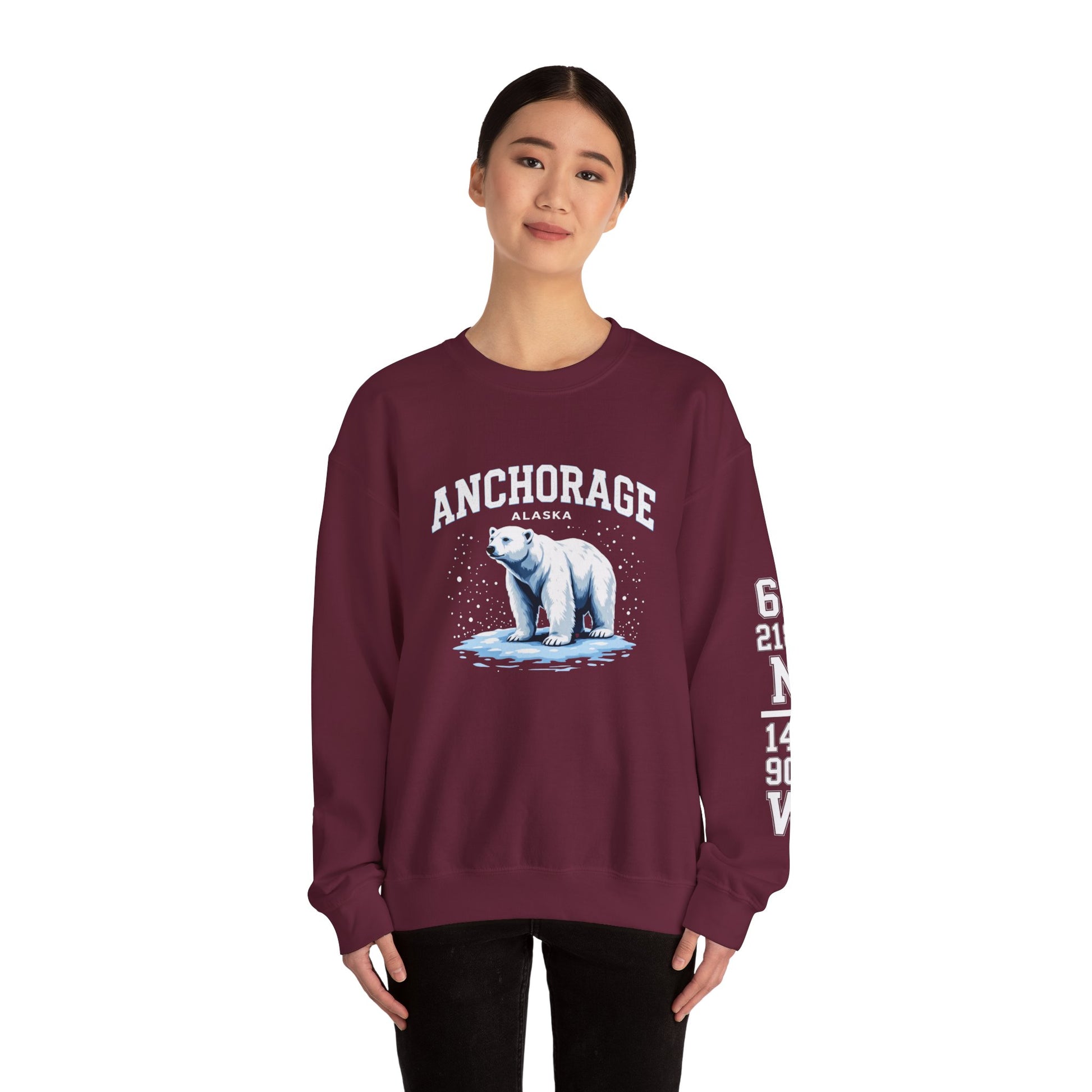 Maroon sweatshirt with polar bear graphic and 'Anchorage Alaska' text worn by a model on a white background