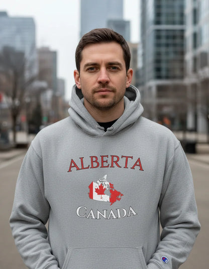 Man wearing a gray hoodie with 'Alberta Canada' text and map design outdoors.
