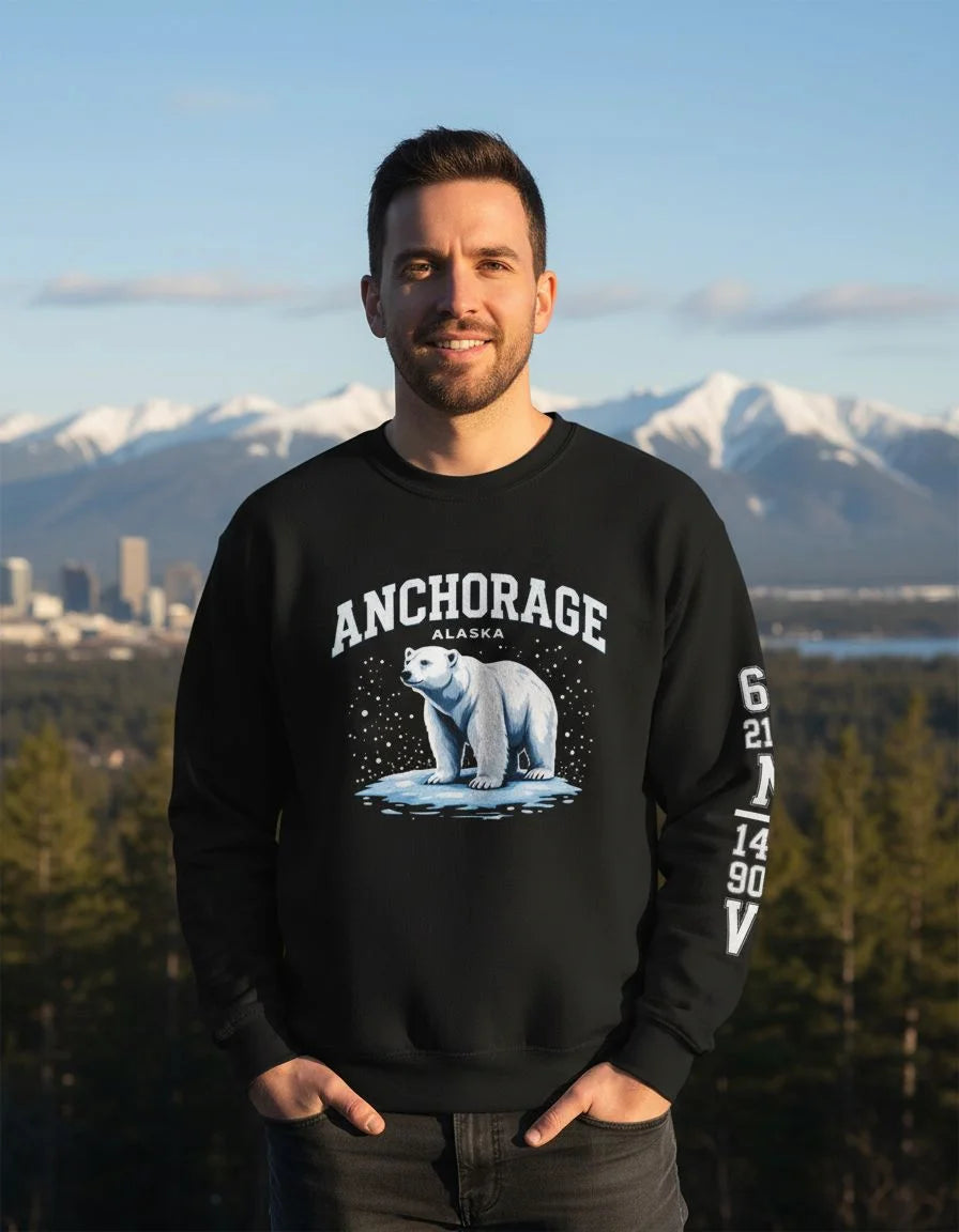 Man wearing a black sweatshirt with a polar bear graphic and 'Anchorage, Alaska' text, standing in front of a mountainous landscape.