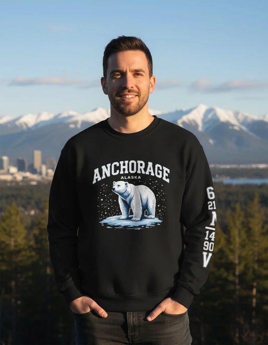 Man wearing a black sweatshirt with a polar bear graphic and 'Anchorage, Alaska' text, standing in front of a mountainous landscape.