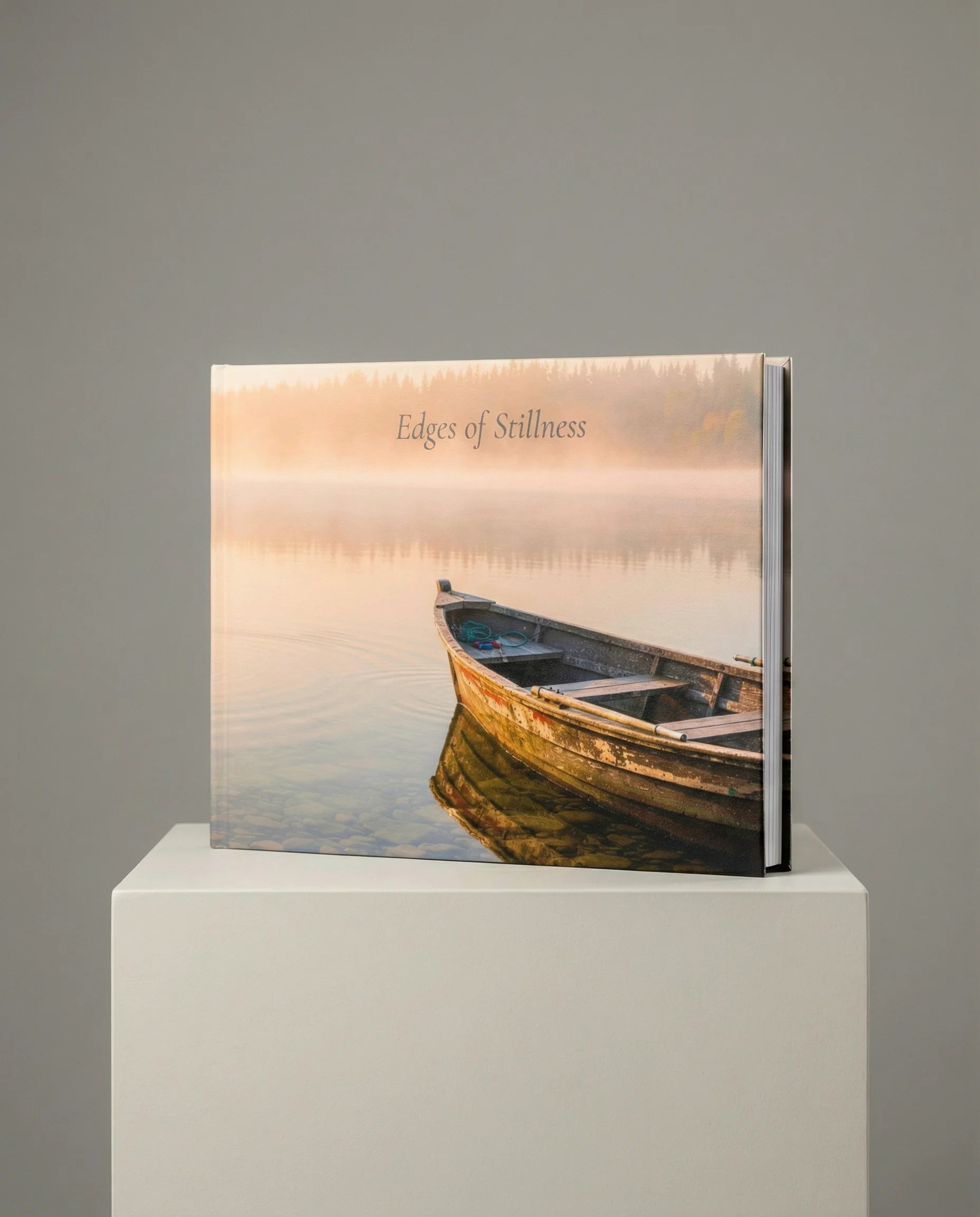 Book titled 'Edges of Stillness' with a boat on water cover on a gray background