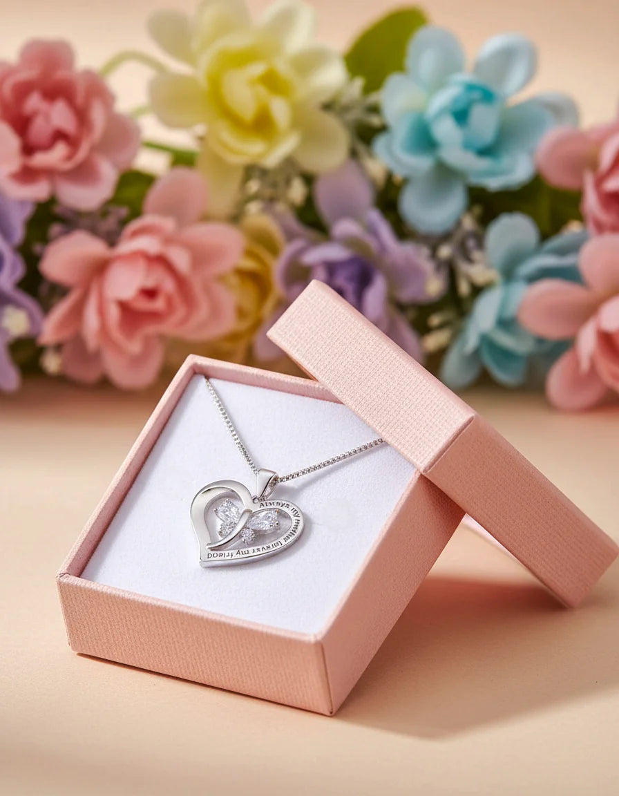 Heart-shaped necklace in a pink box with flowers in the background