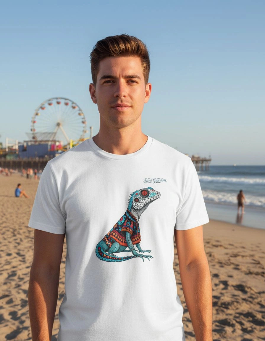 Man wearing a white t-shirt with a colorful lizard design on a beach.