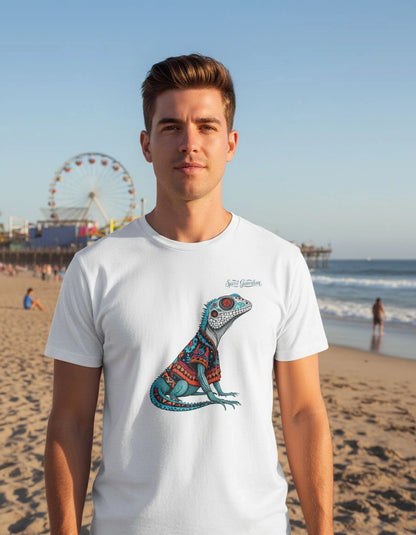 Man wearing a white t-shirt with a colorful lizard design on a beach.