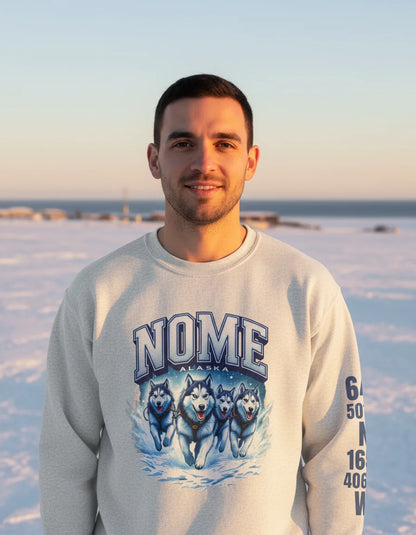 Person wearing a sweatshirt with 'Nome, Alaska' and husky design, standing in a snowy landscape.