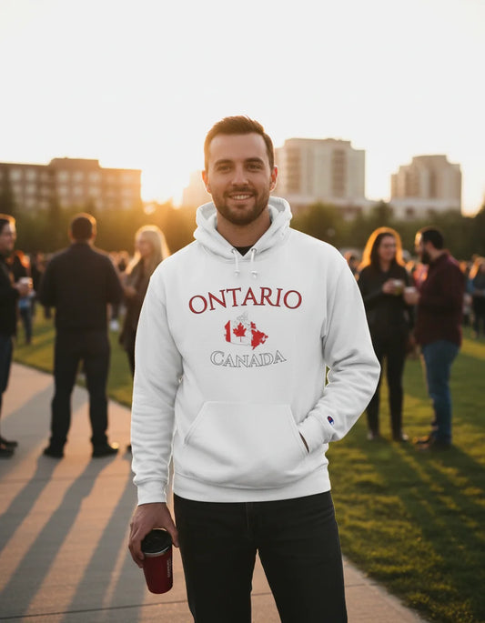 Man wearing a hoodie with 'Ontario Canada' text and a maple leaf, standing outdoors with people and buildings in the background.