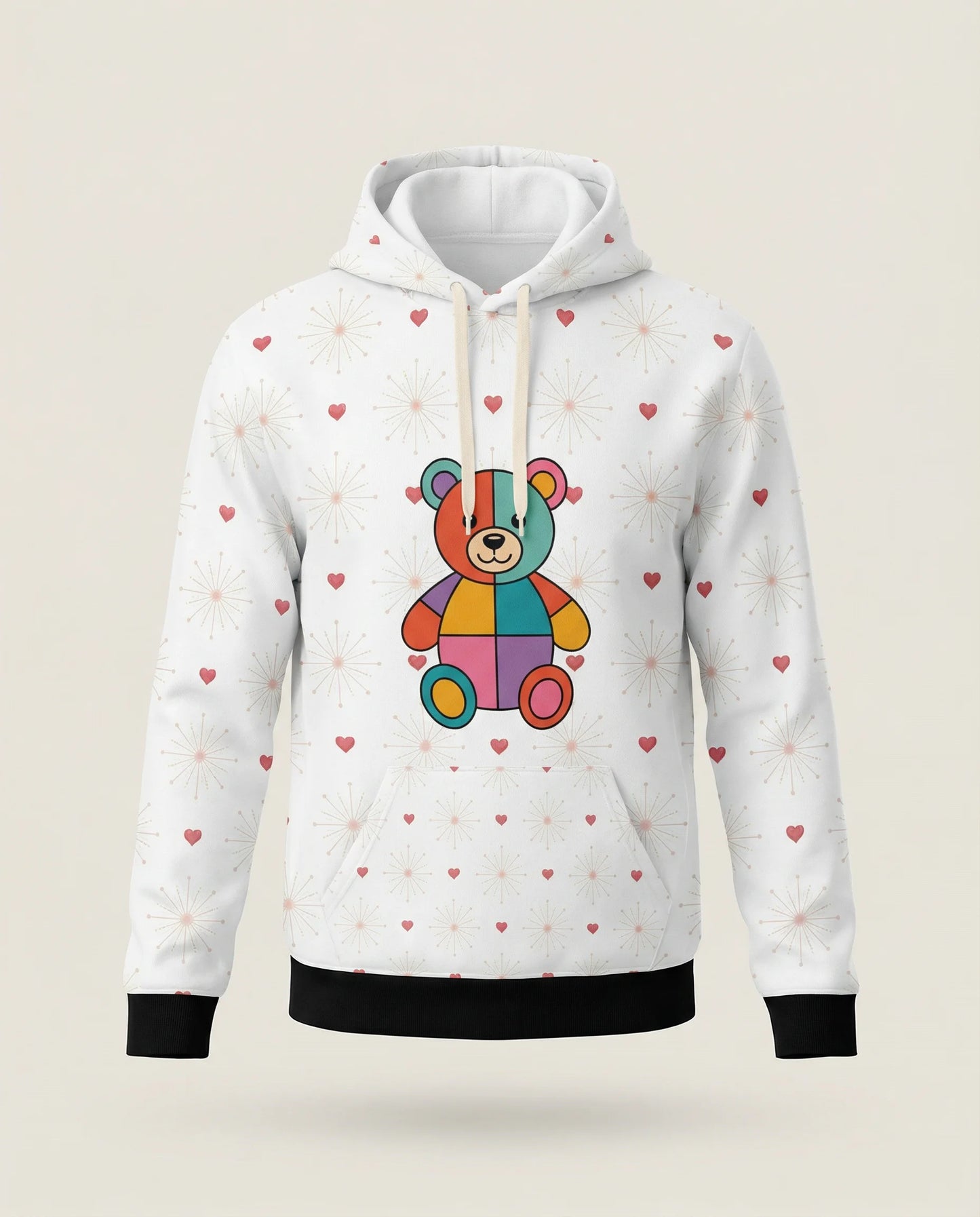 White hoodie with a colorful teddy bear design and heart patterns on a beige background