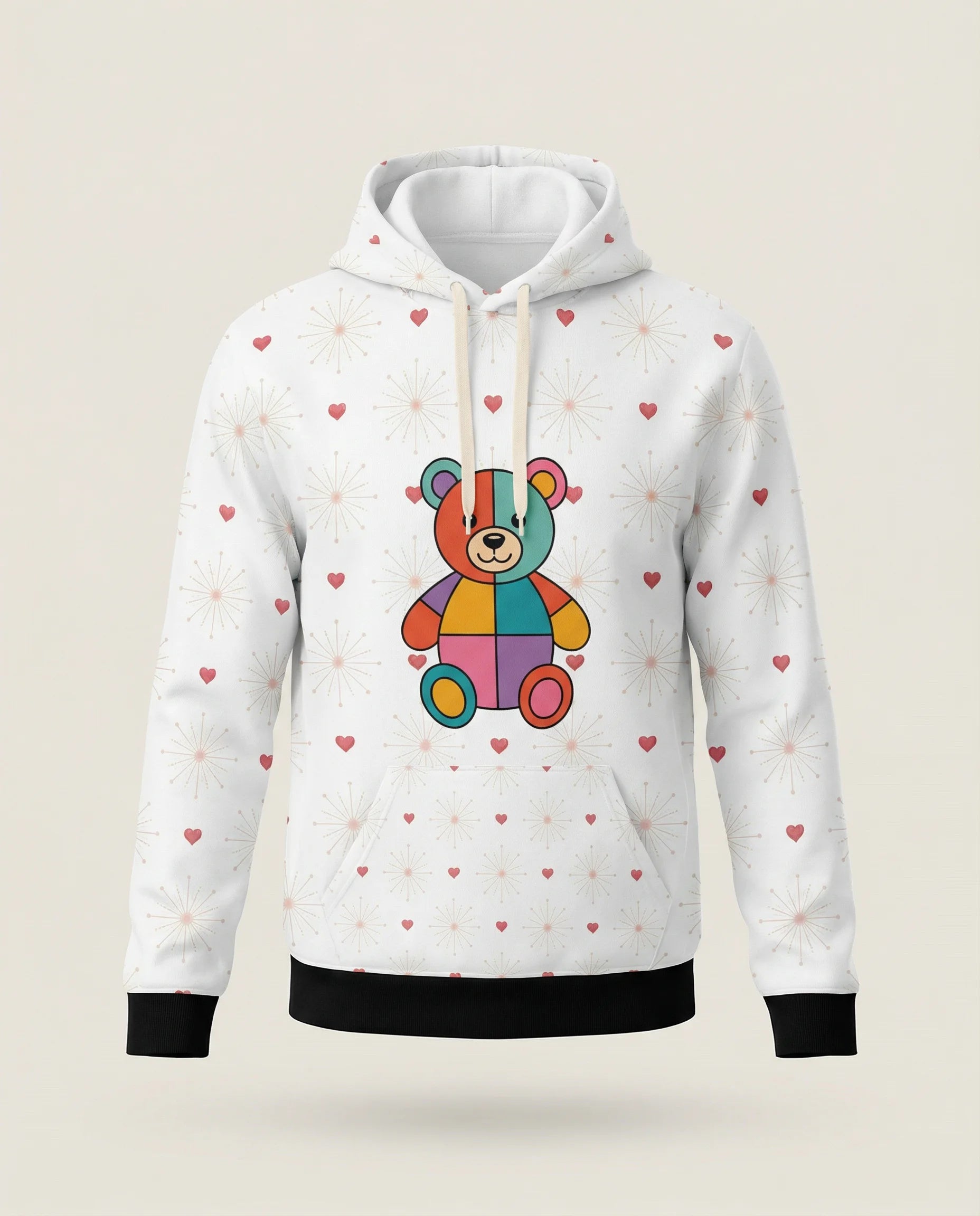 White hoodie with a colorful teddy bear design and heart patterns on a beige background
