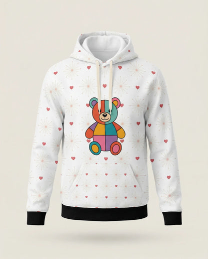 White hoodie with a colorful teddy bear design and heart patterns on a beige background