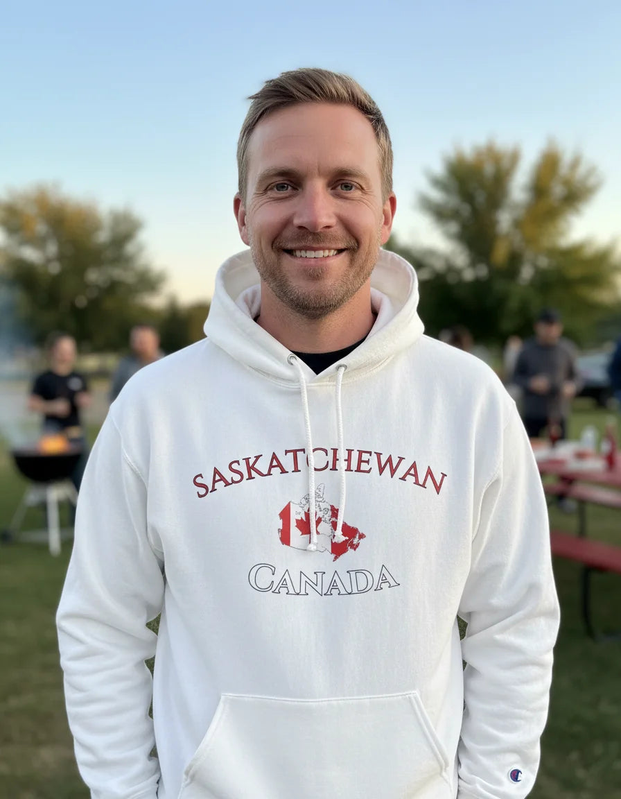 Man wearing a white hoodie with 'Saskatchewan Canada' text and a maple leaf graphic outdoors.