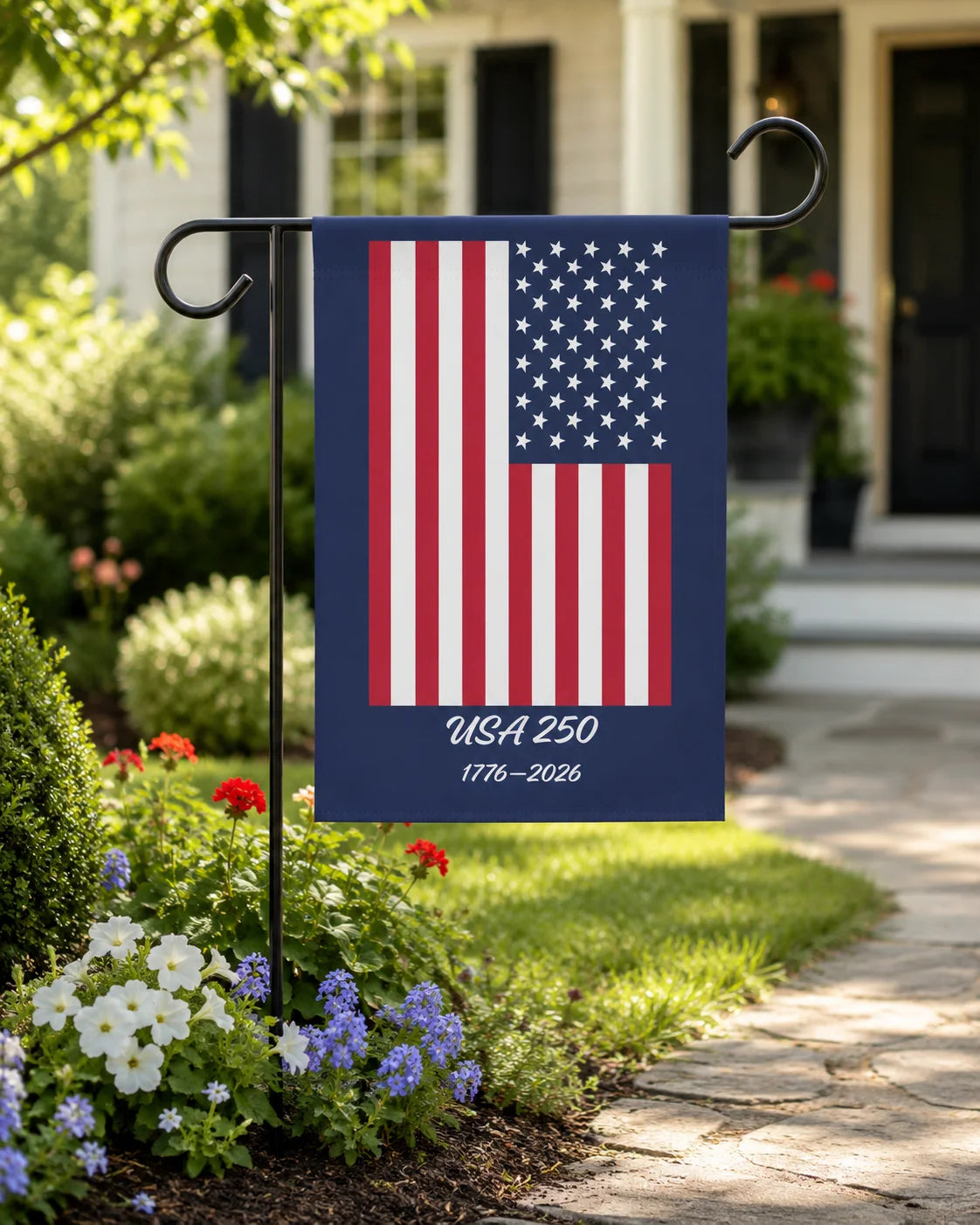 American flag garden flag with 'USA 250' text in a garden setting.