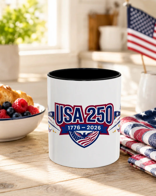 White mug with black interior featuring 'USA 250' design on a wooden table.