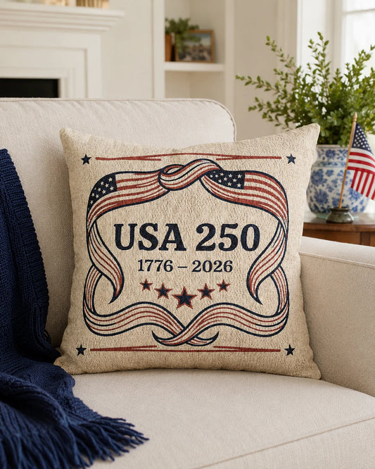 Decorative pillow with 'USA 250' design on a couch in a living room setting.