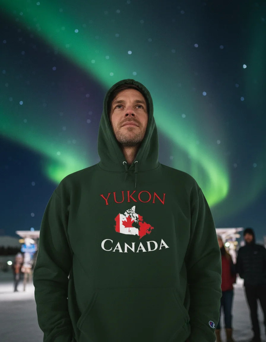 Person wearing a green hoodie with 'Yukon Canada' text and map design against a Northern Lights background.